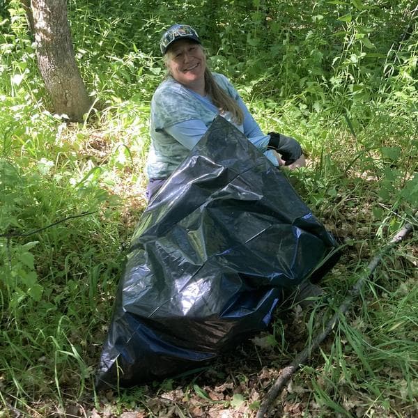 Two volunteers holding full bags of pulled garlic mustard